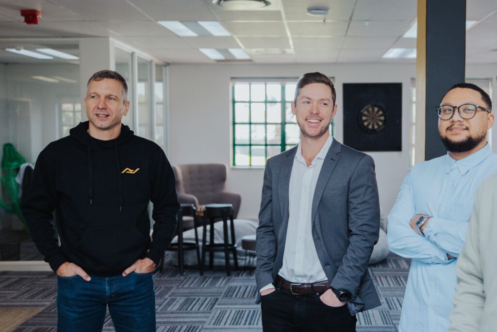 Alex Gasson CEO of Delta-v a leading SDR-as-a-service organisation for the EMEA stands next to two managing Go-to-Market Consultants